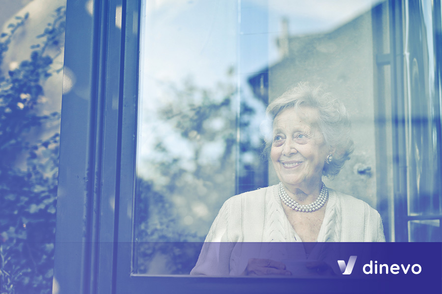 Mujer mayor sonriente viendo a través de la ventana