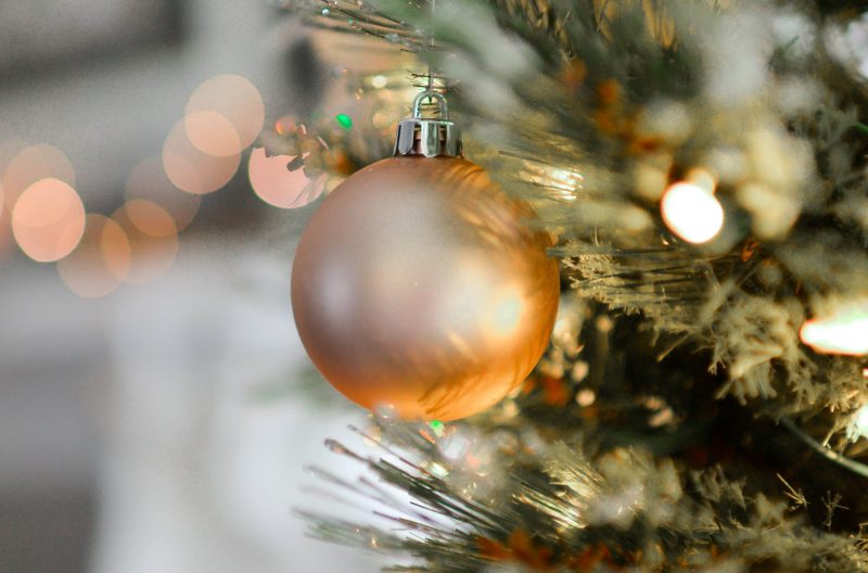 Bola de navidad ocre colgada en un árbol