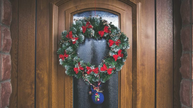 Corona de Navidad colocada sobre puerta de madera