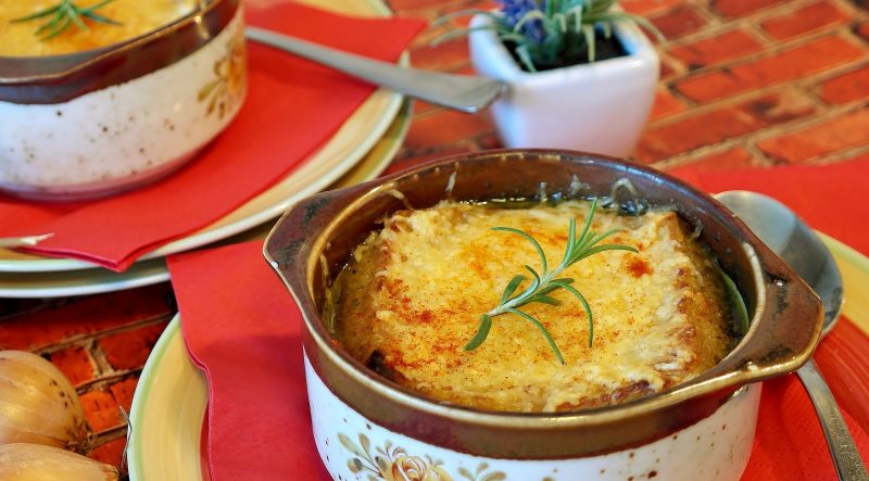 Dos cuencos de sopa de cebolla servida en una mesa